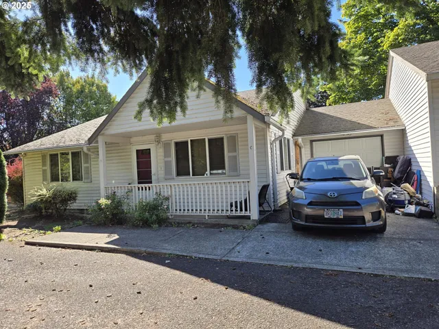 a car parked in front of a white house
