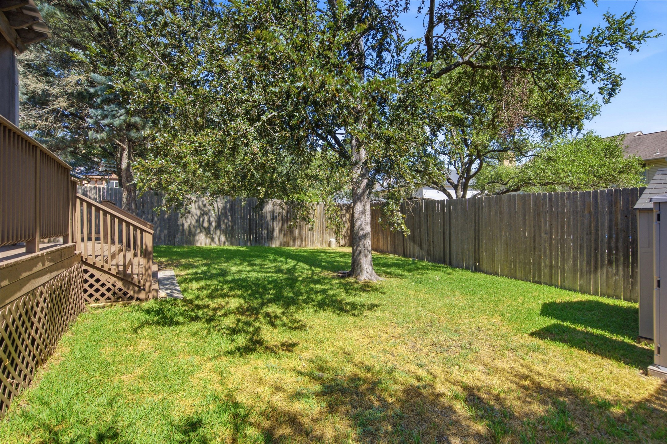 6032 Roxbury Lane Austin, TX 78739 - Photo 29 of 34 Mature trees shade a spacious lawn enclosed by a wooden privacy fence.