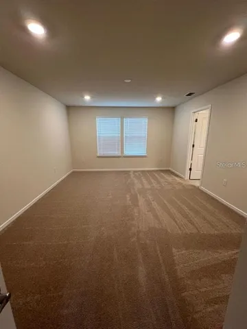 an empty room with a empty space and windows