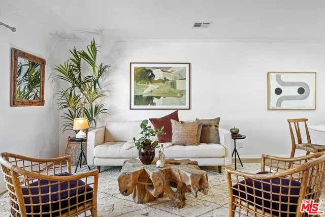 a living room with furniture a couch and paintings on the wall