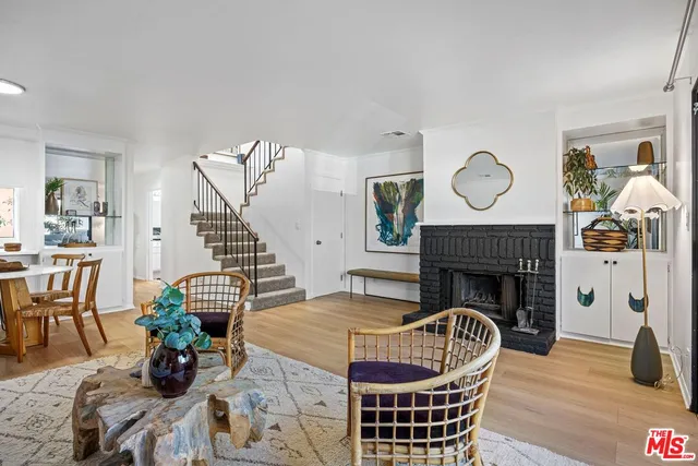 a living room with furniture a fireplace and wooden floor