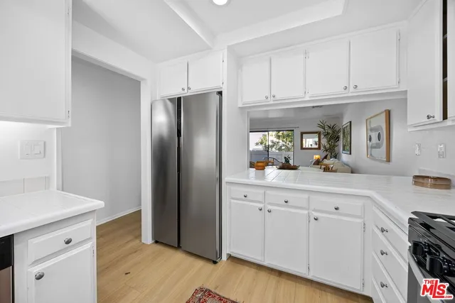 a kitchen with granite countertop white cabinets and stainless steel appliances