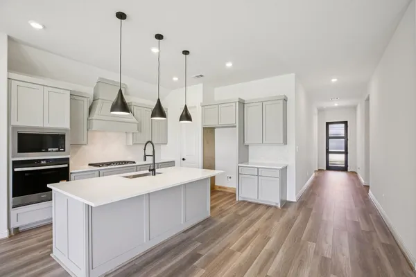 a kitchen with a stove a sink and a refrigerator