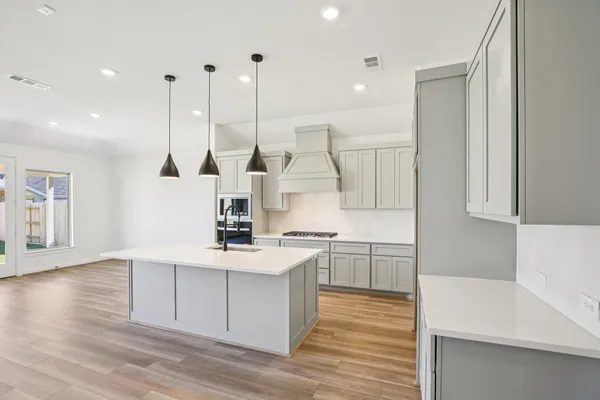 a kitchen with stainless steel appliances granite countertop a sink a stove and a wooden floors