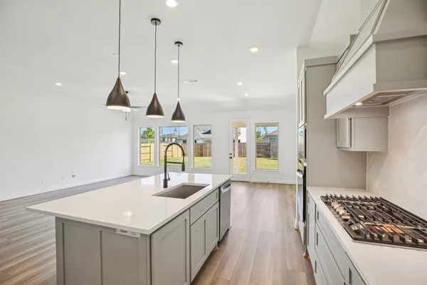 a kitchen with a sink a stove and chairs