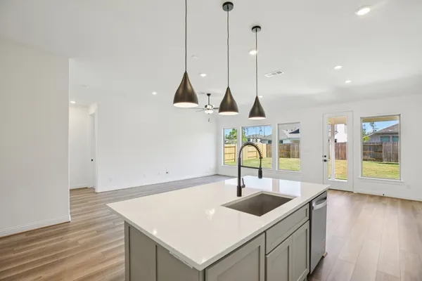 a view of a kitchen island with a sink a wooden floor and a floor to ceiling window