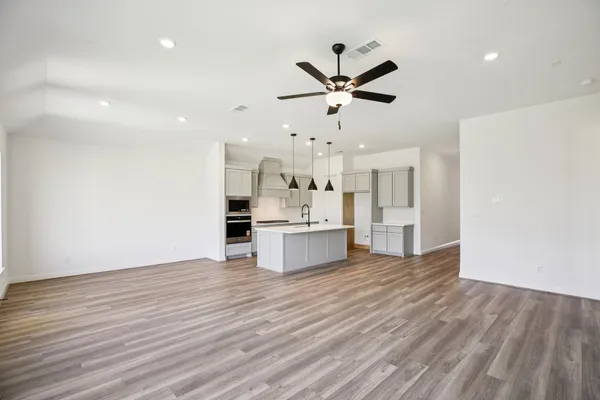 a view of a kitchen with wooden floor and stainless steel appliances