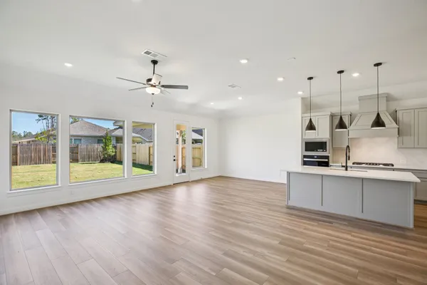 a view of a kitchen with a sink dishwasher and wooden floor