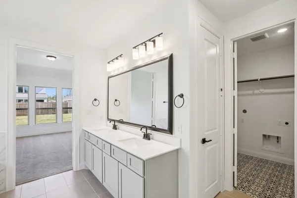 a bathroom with a double vanity sink a mirror and shower