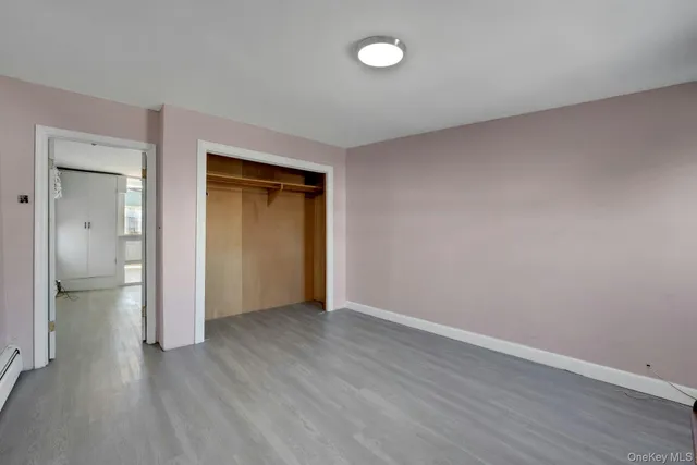 a view of a hallway with wooden floor and a large mirror