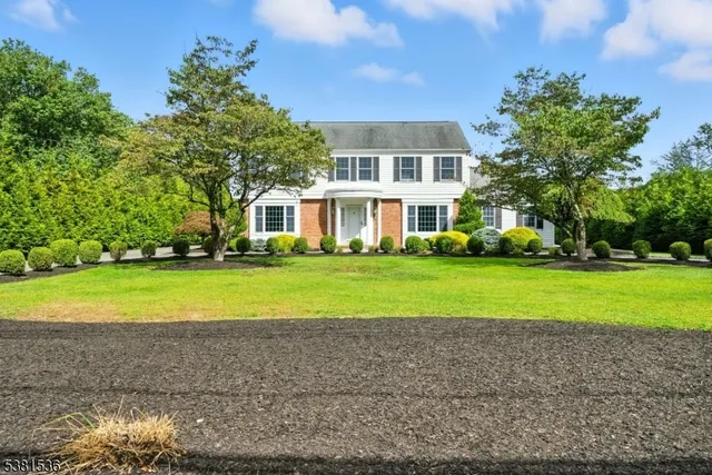 a view of a house with a big yard and large trees