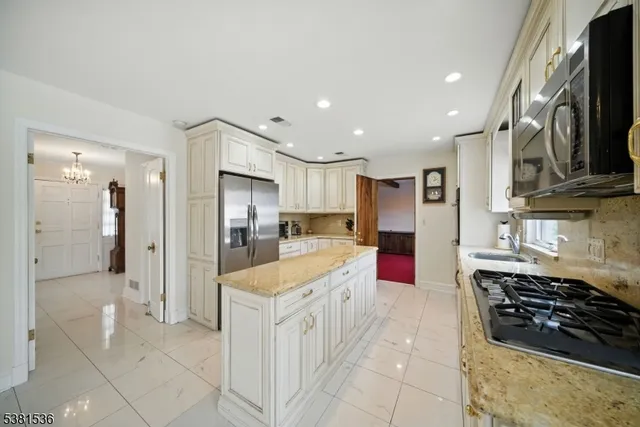 a kitchen with stainless steel appliances granite countertop a refrigerator and a stove