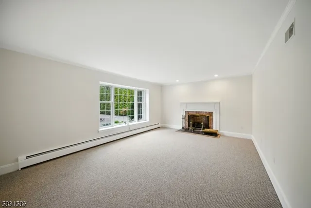 an empty room with fireplace and windows