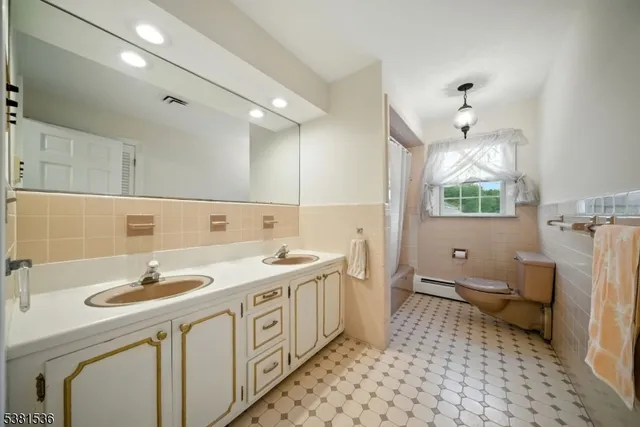 a bathroom with a sink a toilet a mirror and shower