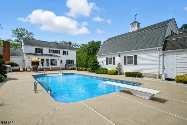 a view of a house with swimming pool and sitting area