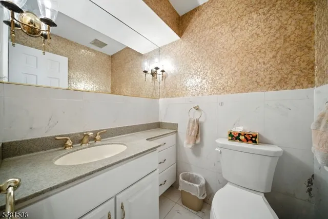 a bathroom with a granite countertop toilet sink and mirror