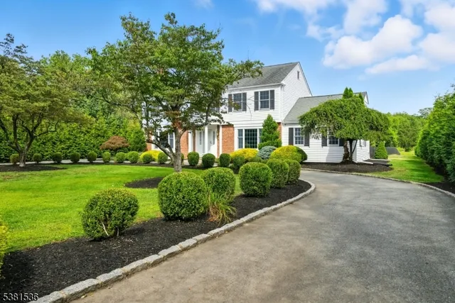 a front view of a house with a yard and potted plants