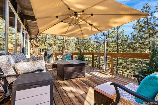 a view of a patio with couches chairs under an umbrella