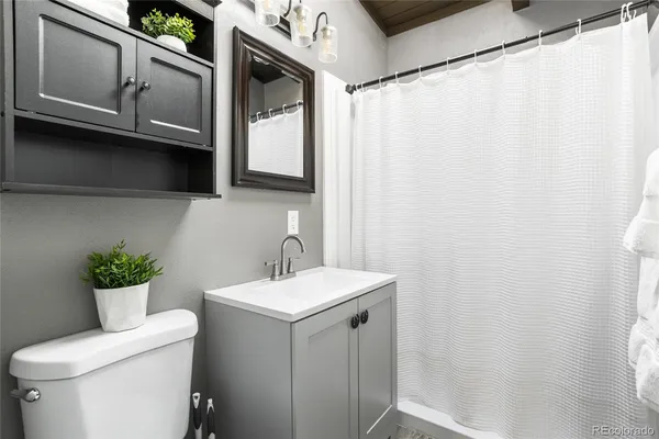 a bathroom with a sink a toilet and mirror
