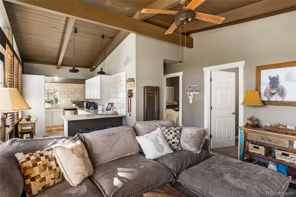 a living room with furniture kitchen view and a window