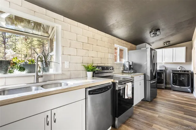 a kitchen with stainless steel appliances granite countertop a sink and a stove