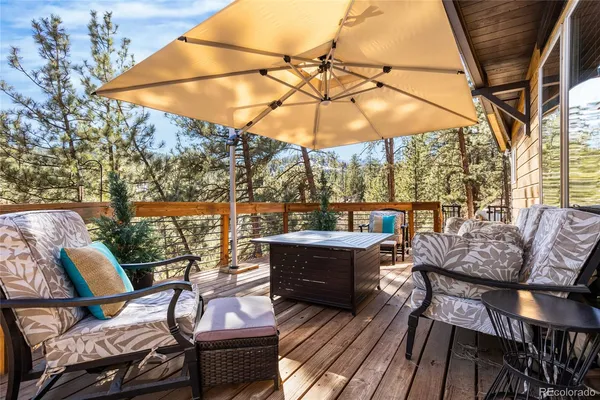 a patio with wooden floor a yard a table and chairs