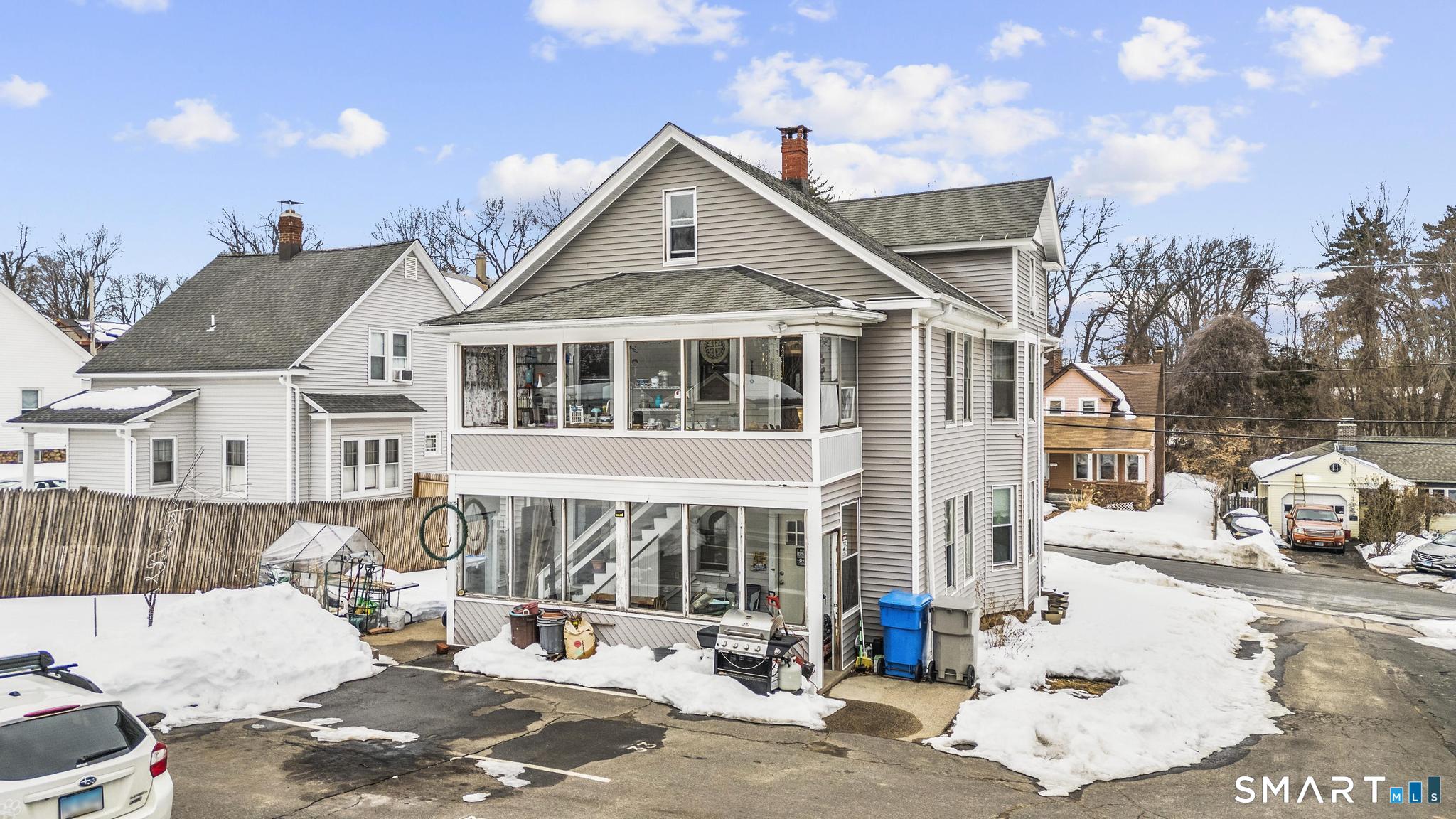 33 Kenney Street Bristol, CT 06010 - Photo 6 of 40 a view of a white house with large windows and a small yard