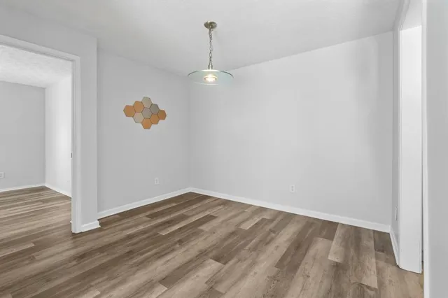 a view of empty room with wooden floor and ceiling fan