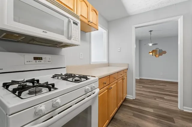 a kitchen with granite countertop white cabinets and white appliances