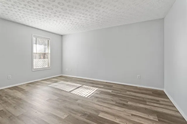 a view of a bedroom with wooden floor and a window