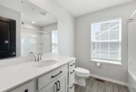 a bathroom with a sink a toilet and a window