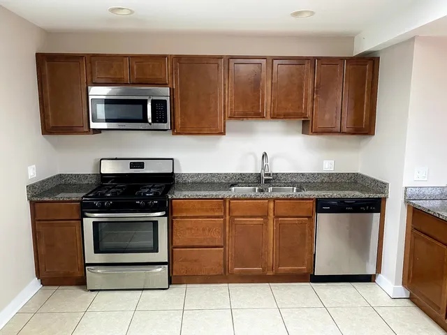 a kitchen with stainless steel appliances granite countertop a stove a microwave and a sink