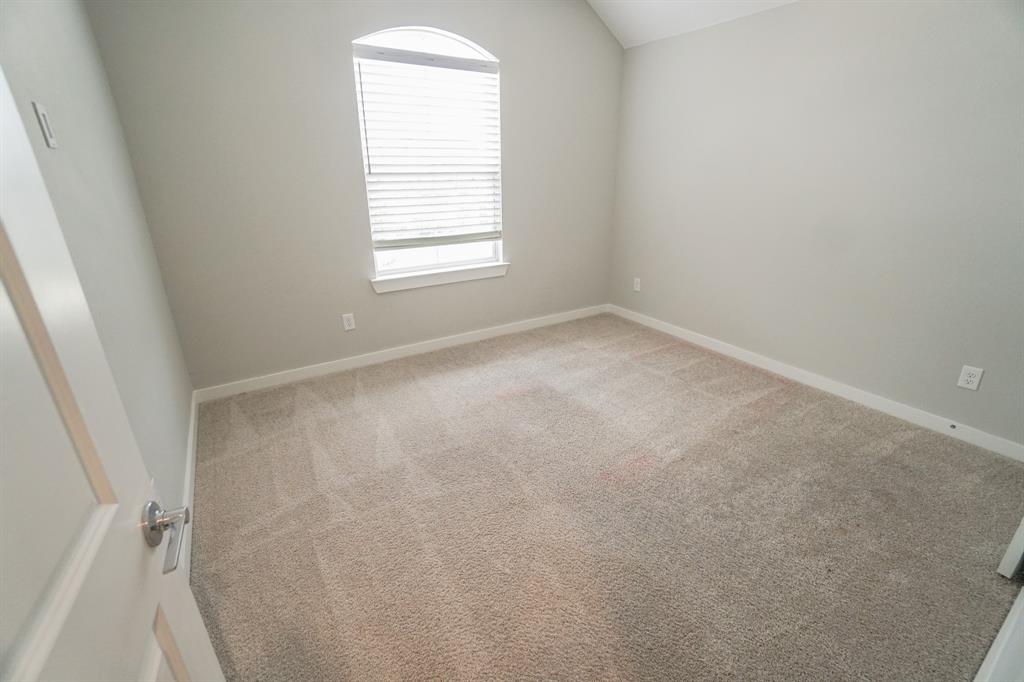 1309 Old Rocksprings Pass Mansfield, TX 76063 - Photo 10 of 36 Carpeted interior room featuring a high arched window with blinds, light gray wall paint, white baseboards, and a vaulted ceiling