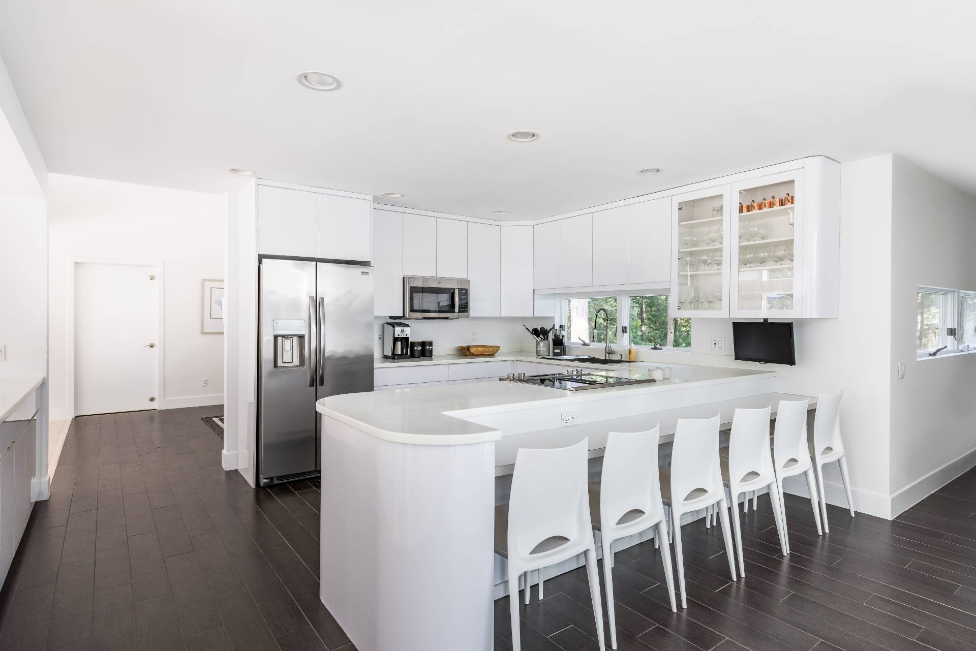 52 Bull Path East Hampton, NY 11937 - Photo 7 of 24 a kitchen with stainless steel appliances a refrigerator a stove a sink dishwasher with a dining table and chairs