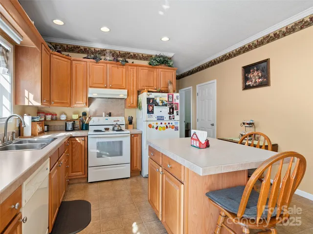 a kitchen with stainless steel appliances granite countertop a stove refrigerator sink and cabinets