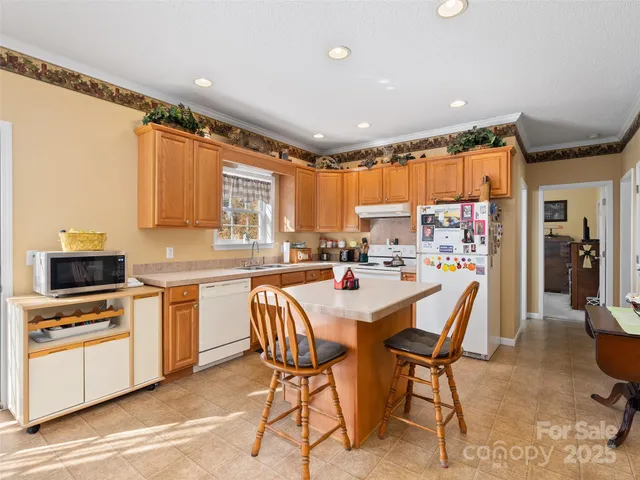 a kitchen with stainless steel appliances granite countertop a stove top oven a sink refrigerator and cabinets