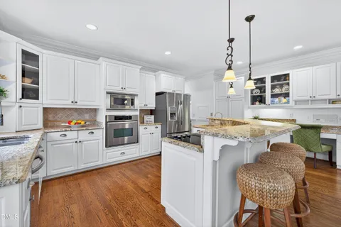 a kitchen with stainless steel appliances granite countertop a stove a sink and a refrigerator