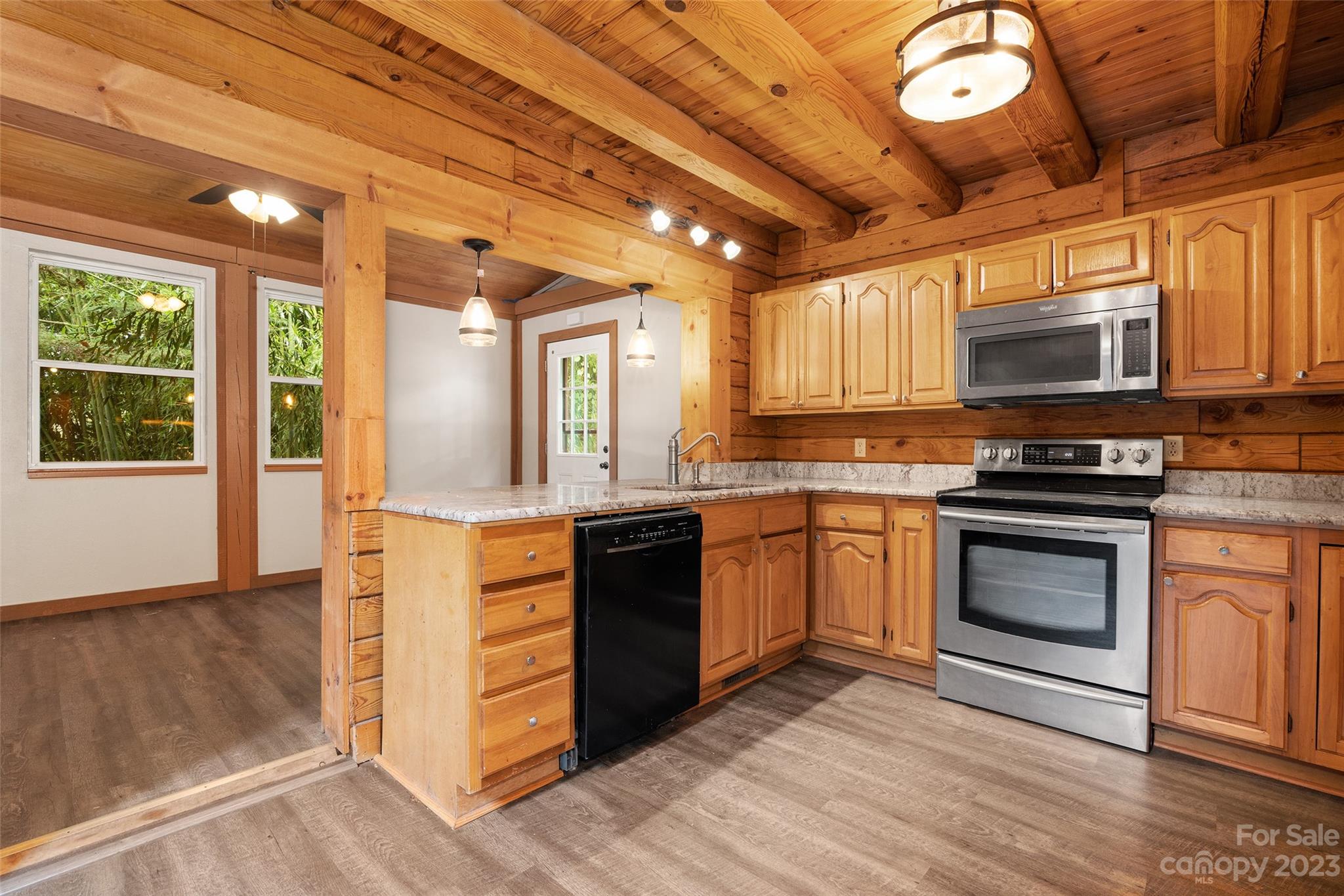 243 Penland Street Clyde, NC 28721 - Photo 6 of 20 a kitchen with stainless steel appliances granite countertop a stove and a microwave