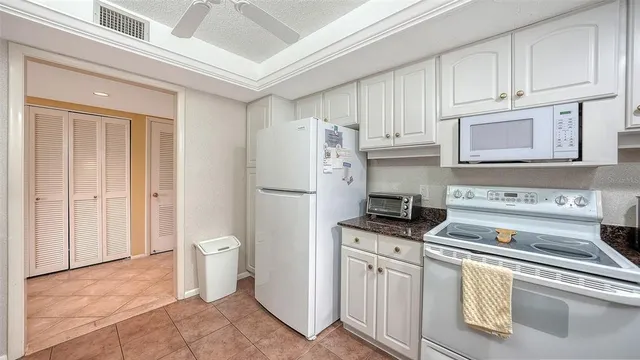 a kitchen with granite countertop white cabinets and sink
