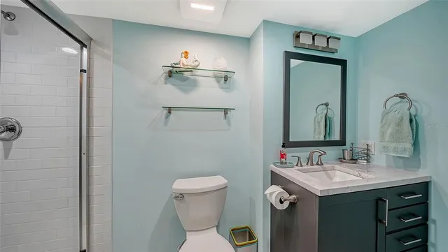 a bathroom with a sink vanity mirror and toilet