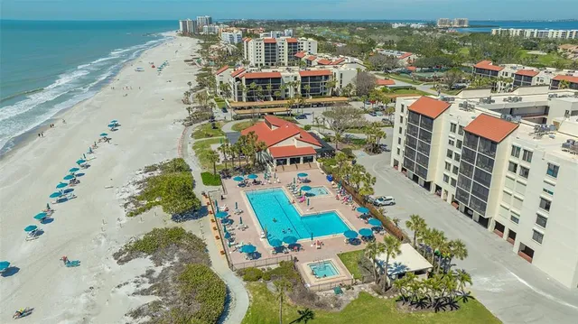 a front view of a building with swimming pool and outdoor seating