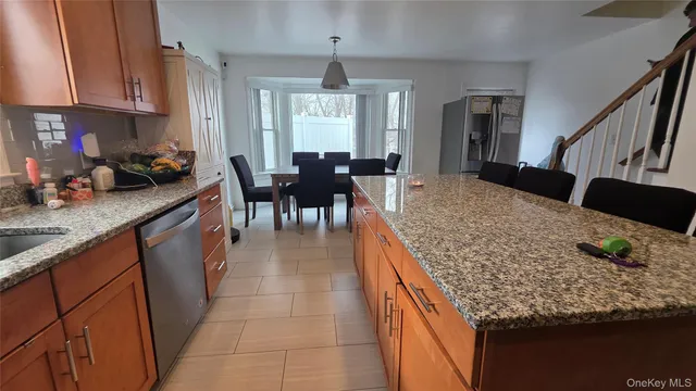 a kitchen with stainless steel appliances granite countertop a sink a stove a refrigerator and cabinets