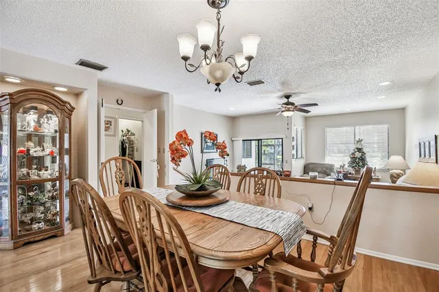 a view of a dining room with furniture a chandelier and wooden floor