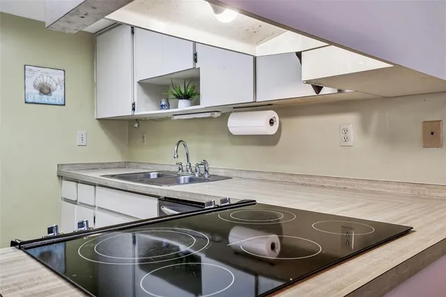 a kitchen with a sink a stove and chairs