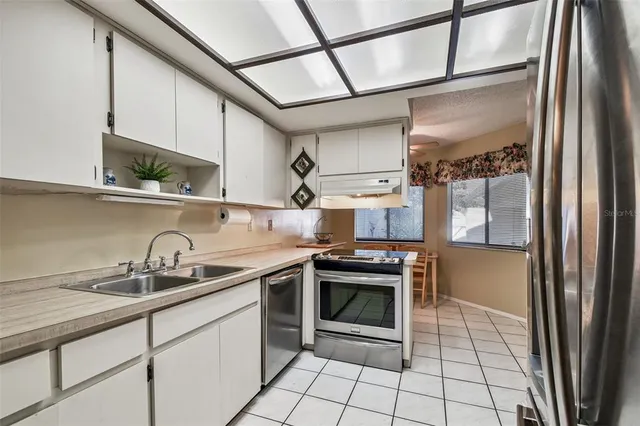 a kitchen with stainless steel appliances granite countertop a sink stove and cabinets