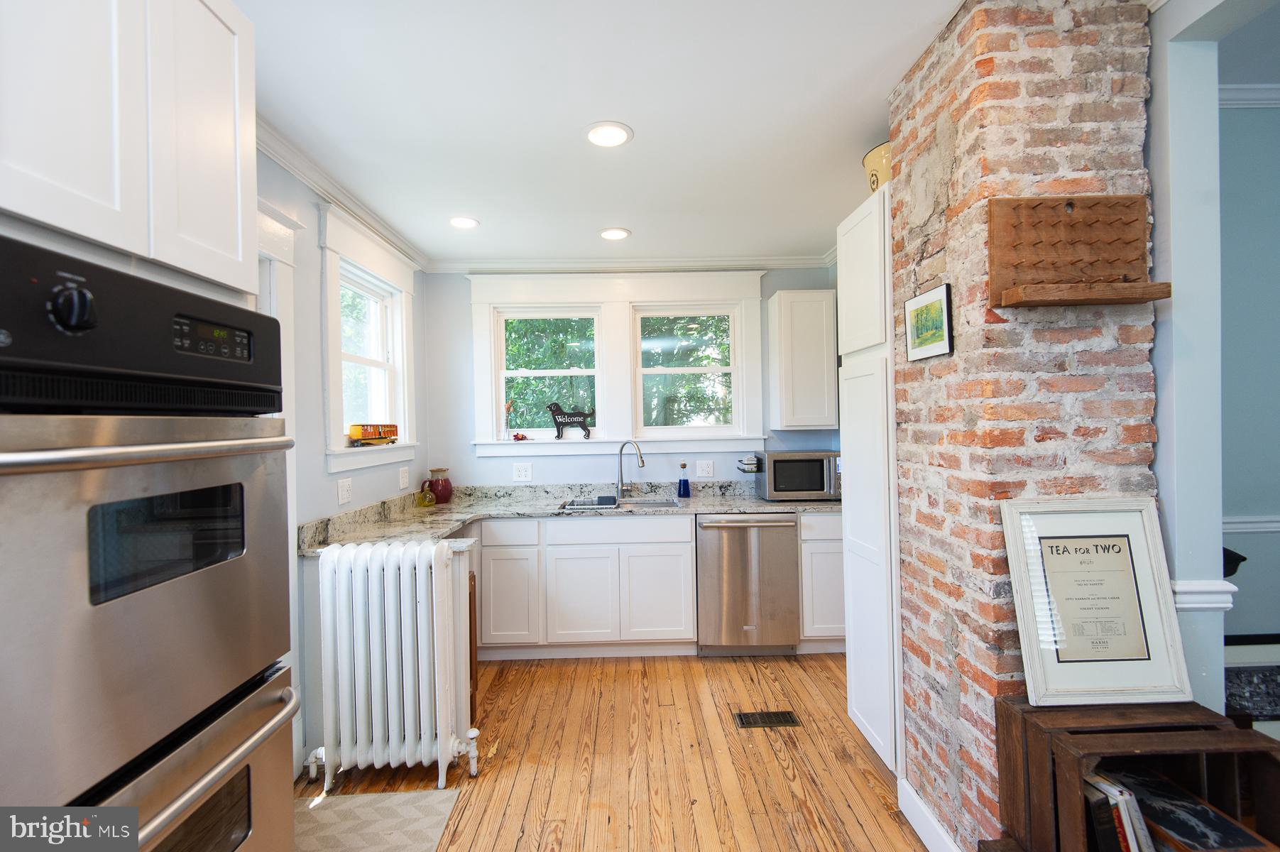 606 Locust Street Cambridge, MD 21613 - Photo 15 of 37 a kitchen with stainless steel appliances granite countertop a stove a sink and a microwave