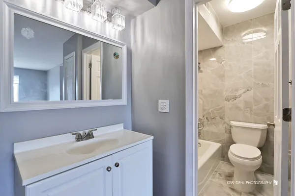 a bathroom with a sink toilet a mirror and shower