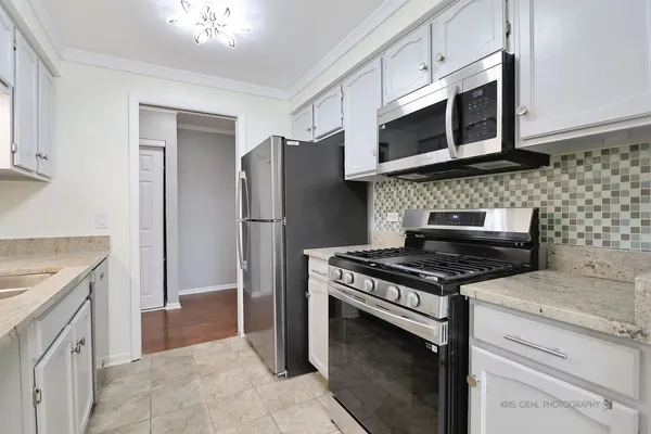 a kitchen with stainless steel appliances granite countertop a stove microwave and refrigerator