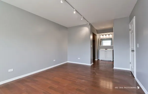 an empty room with wooden floor and mirror