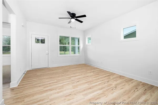 a view of a livingroom with a ceiling fan a hardwood floor and a ceiling fan